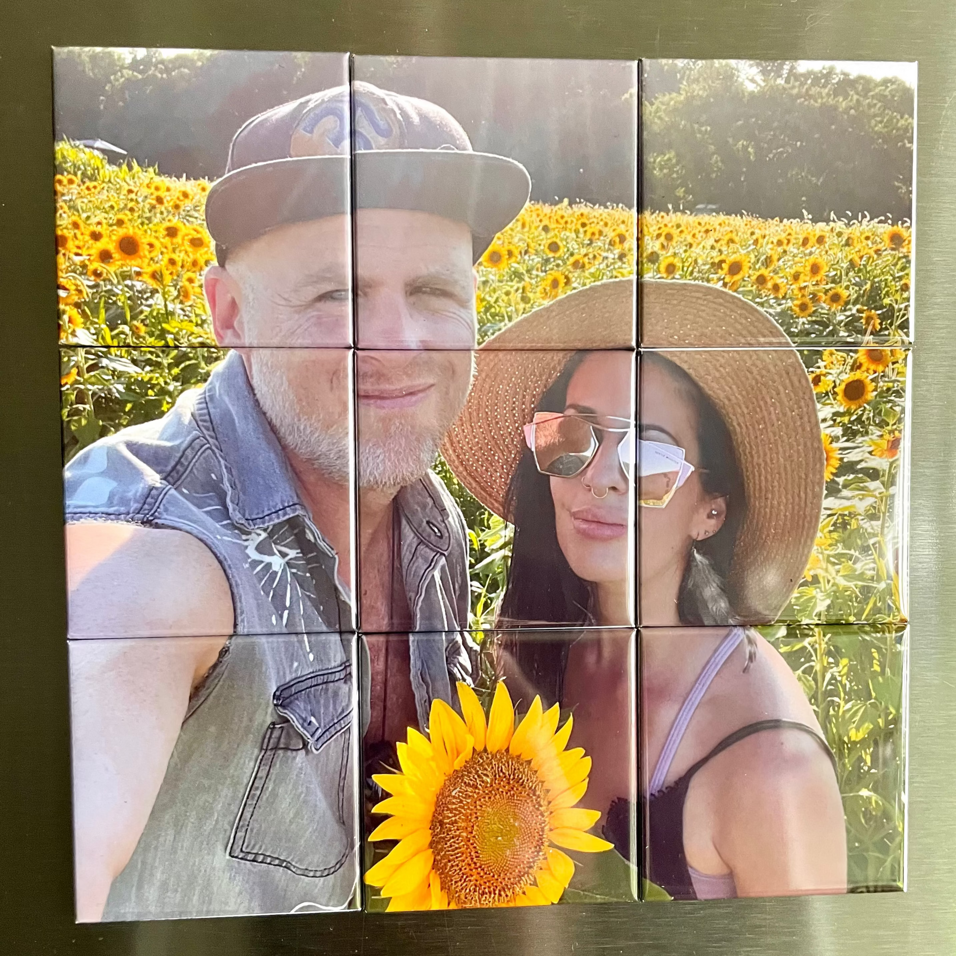 Mosaic of a man and woman in a sunflower field on a metallic surface